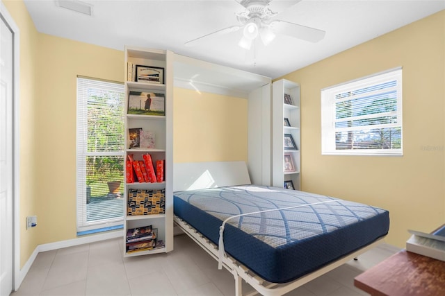 bedroom with tile patterned floors, ceiling fan, and multiple windows