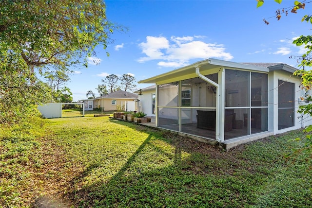 rear view of property with a sunroom and a yard