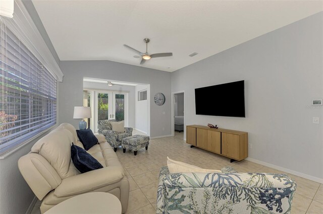 tiled living room with ceiling fan and vaulted ceiling