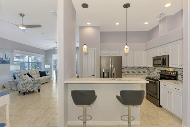 kitchen featuring a breakfast bar area, light tile patterned floors, light stone counters, white cabinetry, and stainless steel appliances