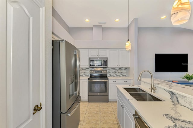 kitchen featuring pendant lighting, sink, white cabinets, and stainless steel appliances