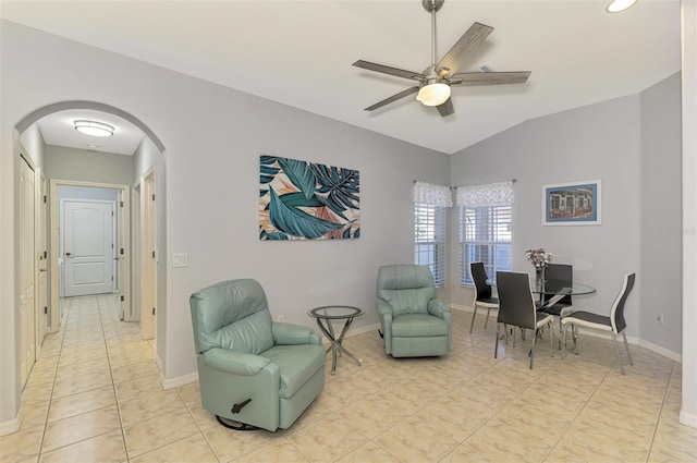 living area featuring ceiling fan, lofted ceiling, and light tile patterned floors