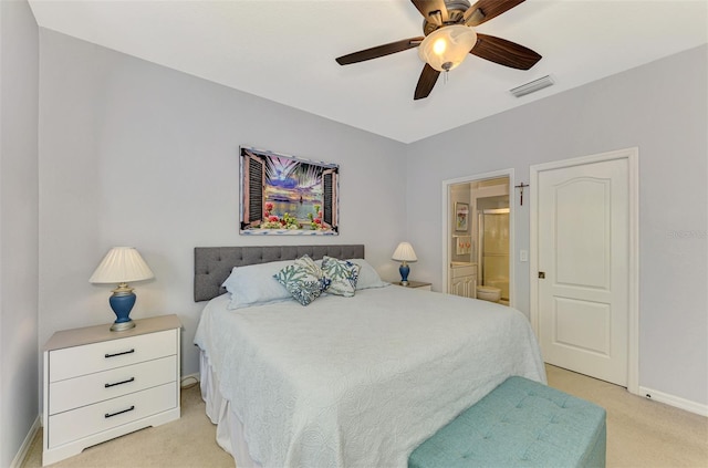 bedroom with connected bathroom, light colored carpet, and ceiling fan