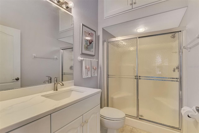 bathroom with toilet, vanity, tile patterned floors, and walk in shower