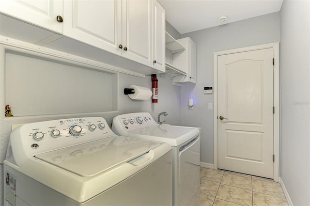 washroom featuring cabinets, independent washer and dryer, and light tile patterned floors