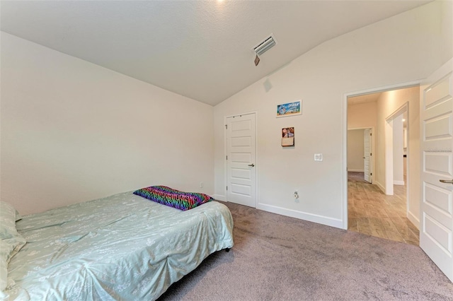 carpeted bedroom featuring lofted ceiling