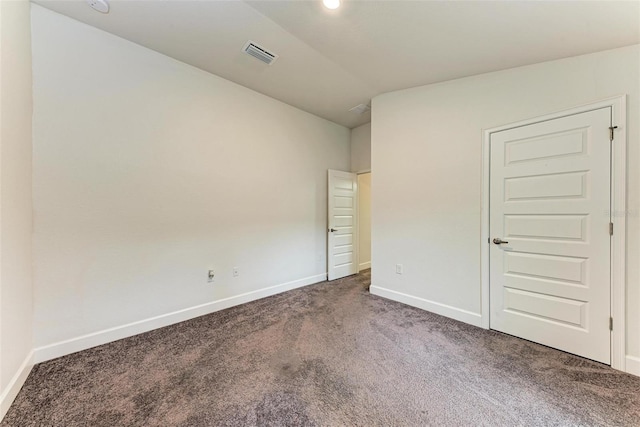 carpeted spare room featuring vaulted ceiling