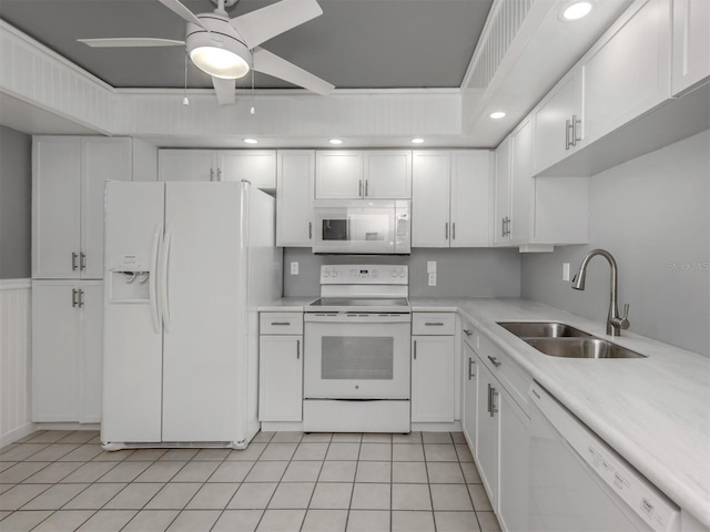 kitchen with sink, white cabinets, light tile patterned floors, ceiling fan, and white appliances