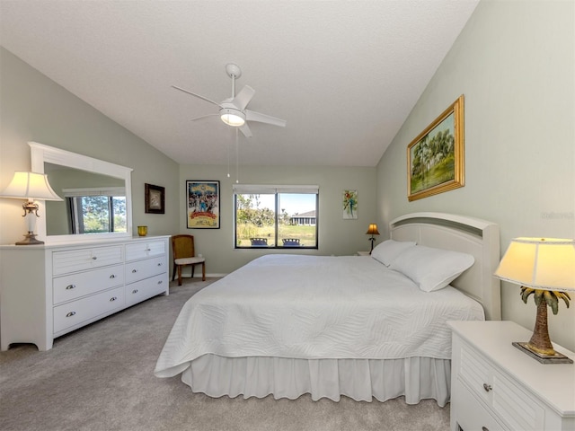 carpeted bedroom featuring lofted ceiling, a textured ceiling, and ceiling fan