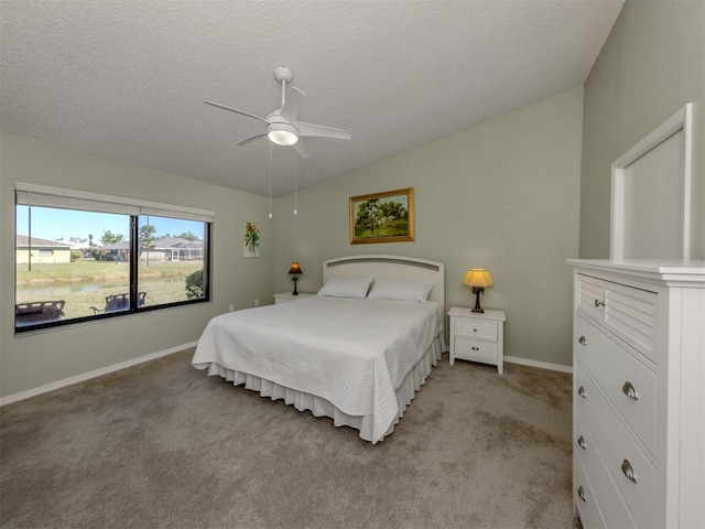 carpeted bedroom with a textured ceiling, vaulted ceiling, and ceiling fan