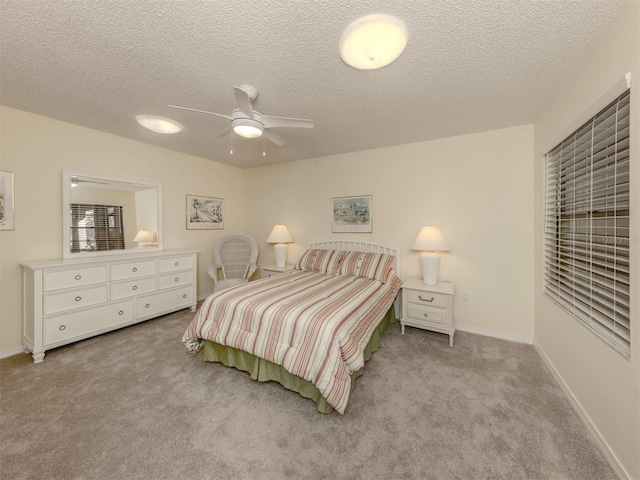 carpeted bedroom with a textured ceiling and ceiling fan