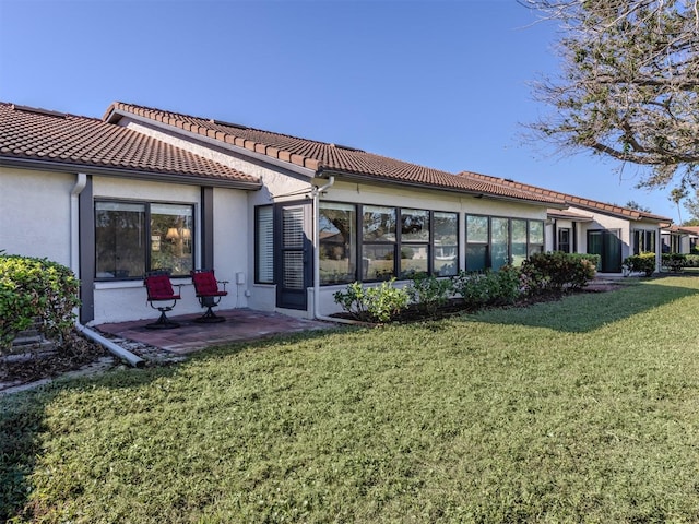 back of house featuring a patio and a lawn