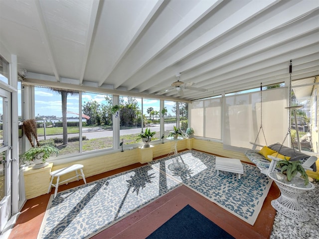 sunroom / solarium featuring ceiling fan and beamed ceiling