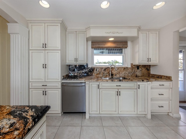 kitchen featuring dark stone countertops, white cabinetry, sink, and stainless steel dishwasher