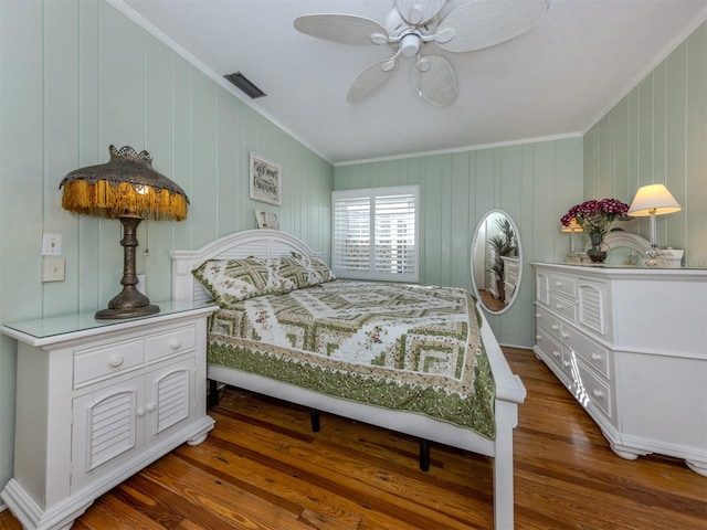 bedroom featuring ceiling fan, dark hardwood / wood-style flooring, and crown molding