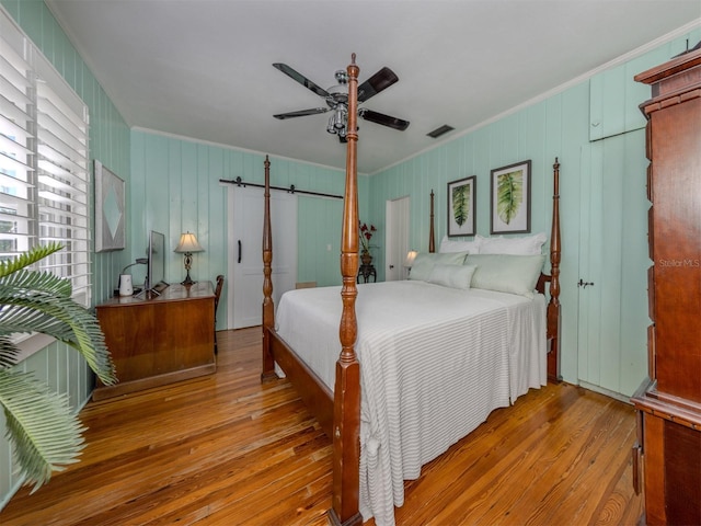 bedroom featuring ceiling fan, wood-type flooring, and crown molding