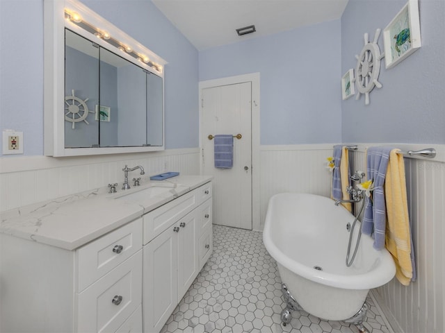 bathroom with tile patterned flooring, vanity, and a tub