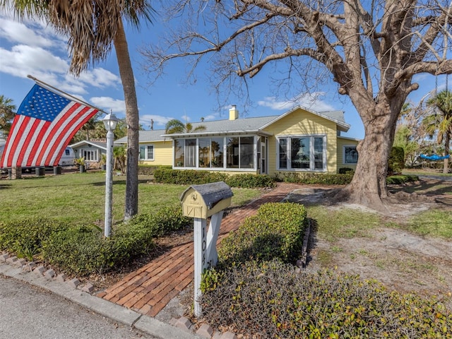 view of front of home featuring a sunroom and a front yard