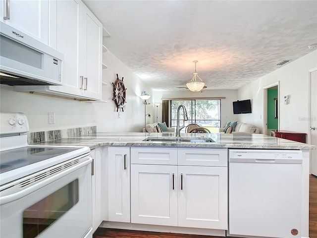 kitchen featuring white cabinetry, sink, dark wood-type flooring, kitchen peninsula, and white appliances