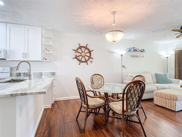 dining space with ceiling fan, sink, and dark hardwood / wood-style floors