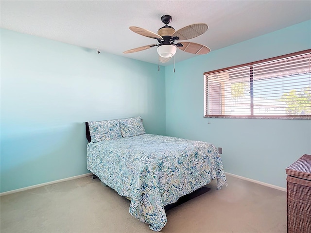 bedroom with ceiling fan and light carpet