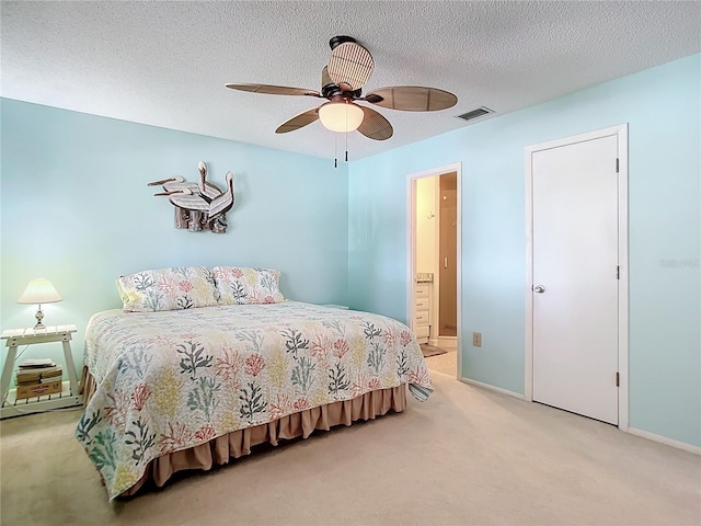 carpeted bedroom featuring ceiling fan and a textured ceiling