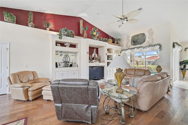 living room with hardwood / wood-style floors, high vaulted ceiling, and ceiling fan