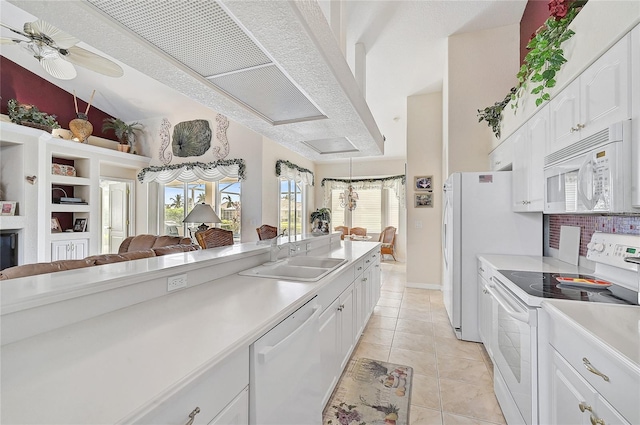 kitchen with white cabinetry, white appliances, sink, and light tile patterned floors