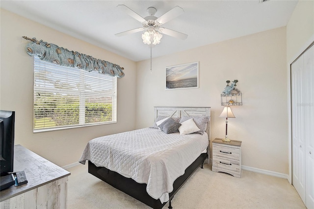 carpeted bedroom featuring a closet and ceiling fan