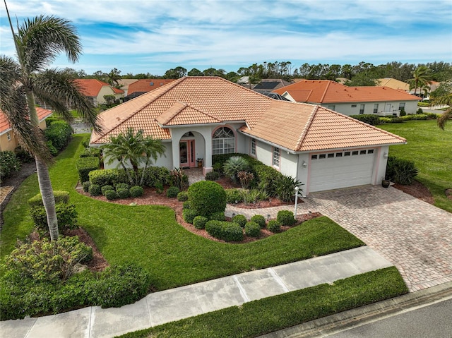 mediterranean / spanish house with a front yard and a garage