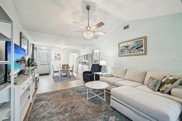 living room featuring lofted ceiling, ceiling fan, and light wood-type flooring