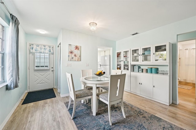 dining room with light hardwood / wood-style flooring and a notable chandelier