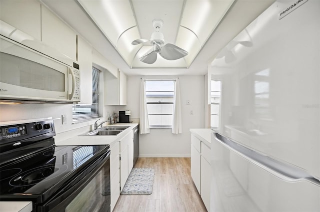 kitchen with white appliances, ceiling fan, sink, white cabinets, and light hardwood / wood-style floors