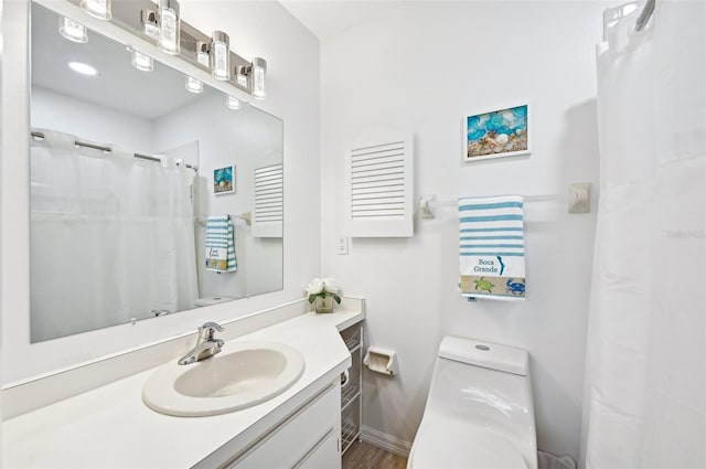 bathroom with walk in shower, hardwood / wood-style floors, vanity, and toilet