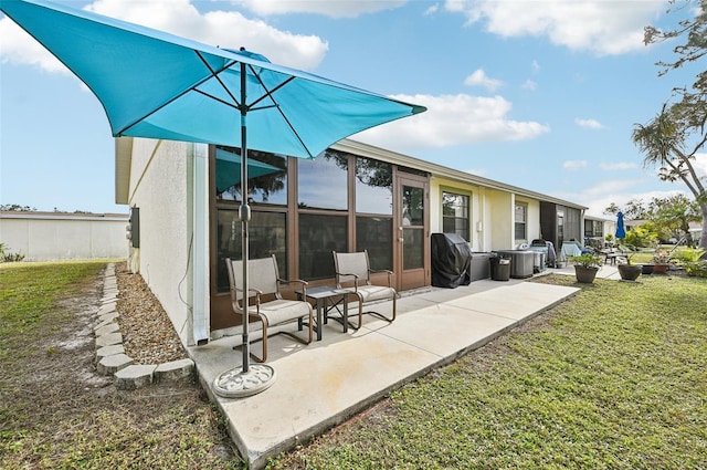 back of house with a lawn and a patio