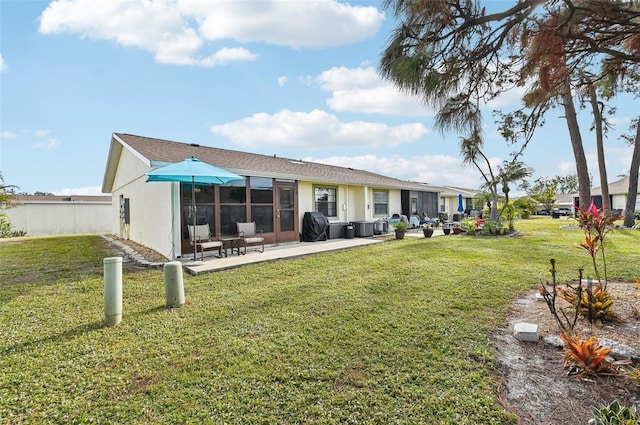 back of property with a yard and a patio