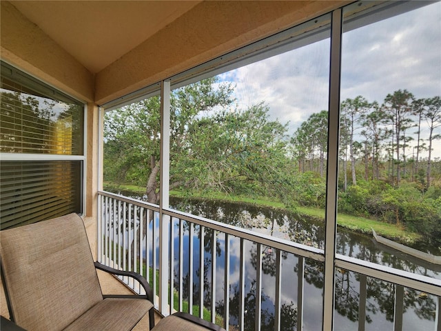 unfurnished sunroom featuring vaulted ceiling and a water view