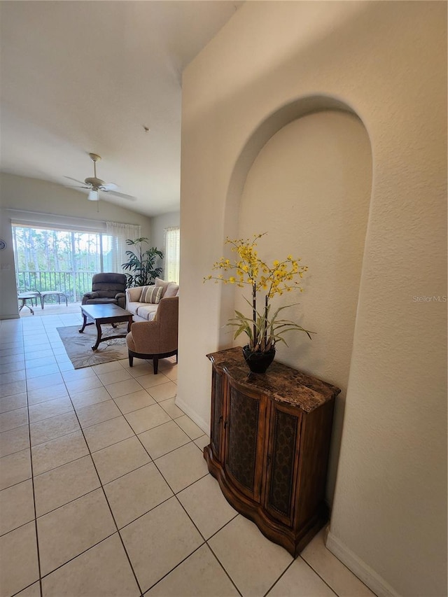 hall with vaulted ceiling and light tile patterned floors