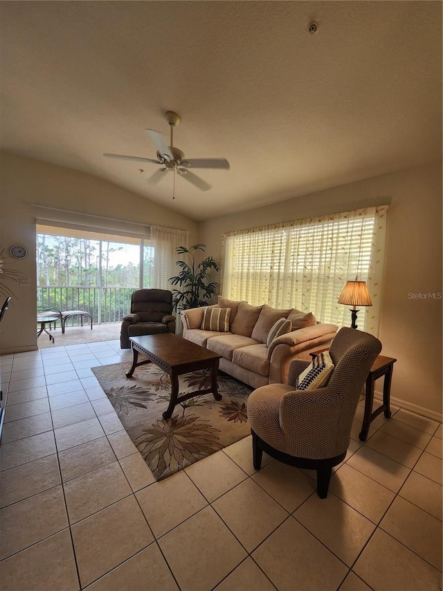 living room with lofted ceiling, light tile patterned floors, and ceiling fan