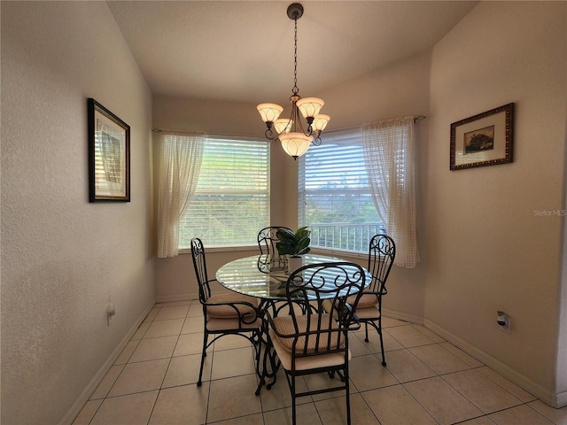 dining area with vaulted ceiling, light tile patterned floors, and an inviting chandelier