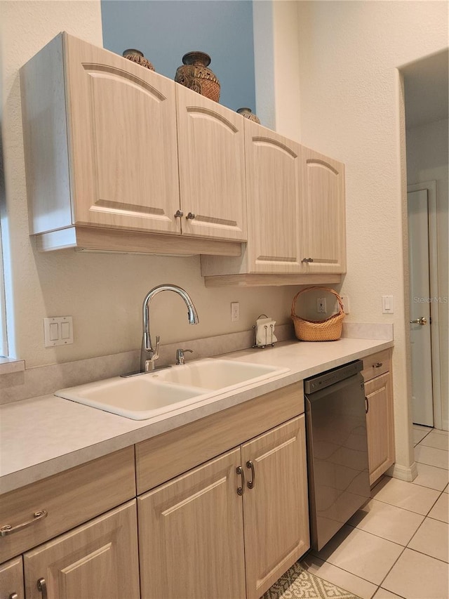 kitchen with dishwasher, sink, light tile patterned flooring, and light brown cabinetry