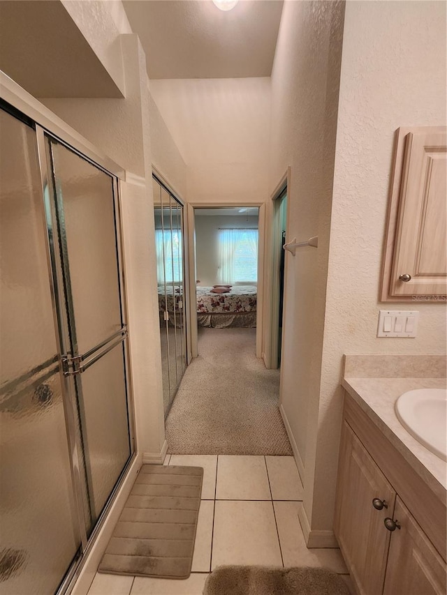 bathroom with vanity, an enclosed shower, and tile patterned floors