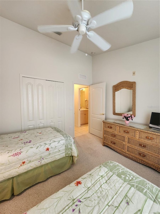 bedroom with ceiling fan, light colored carpet, high vaulted ceiling, and a closet