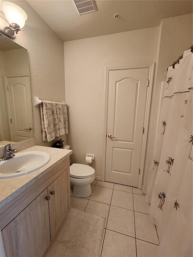 bathroom featuring vanity, toilet, and tile patterned flooring