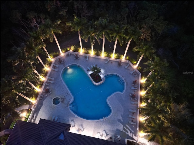 view of pool at twilight