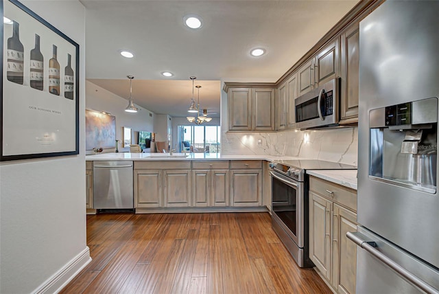 kitchen with backsplash, sink, decorative light fixtures, dark hardwood / wood-style flooring, and stainless steel appliances