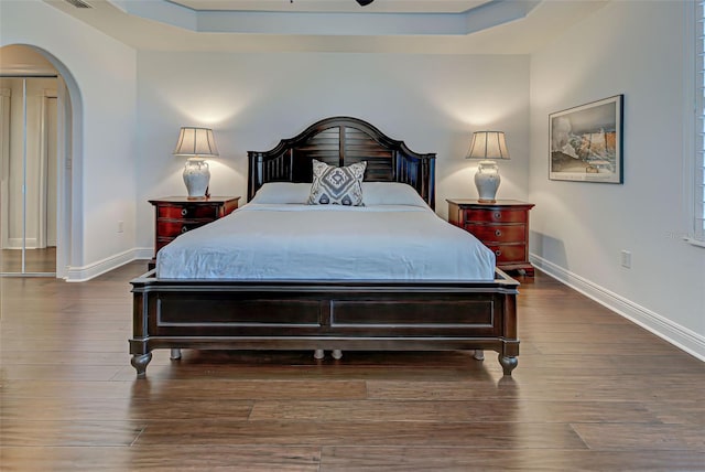 bedroom featuring dark hardwood / wood-style flooring and a raised ceiling