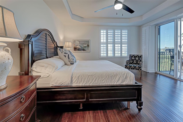 bedroom featuring access to outside, a raised ceiling, ceiling fan, and hardwood / wood-style floors