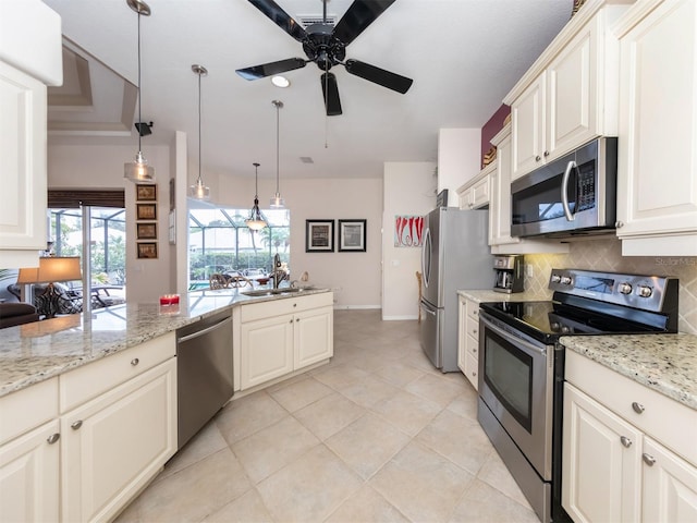 kitchen with ceiling fan, light stone countertops, stainless steel appliances, tasteful backsplash, and pendant lighting