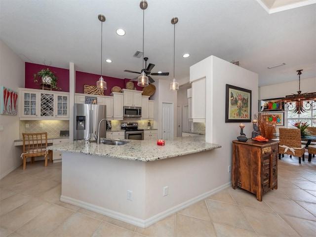 kitchen featuring ceiling fan, sink, tasteful backsplash, decorative light fixtures, and appliances with stainless steel finishes